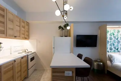 a small kitchen with a white refrigerator and a table at The Sherbrooke Suite 103 in Montréal