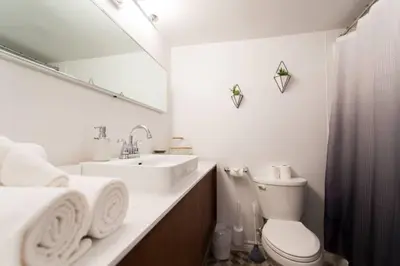 a bathroom with a sink and a toilet and a mirror at The Sherbrooke Suite 103 in Montréal