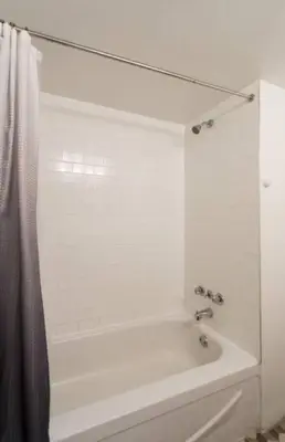 a white bath tub with a shower curtain in a bathroom at The Sherbrooke Suite 103 in Montréal