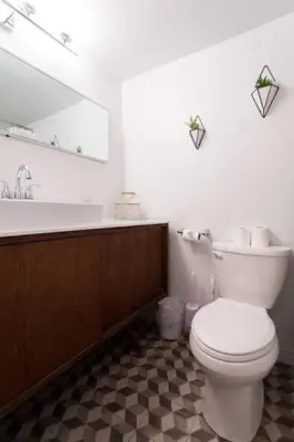a bathroom with a white toilet and a mirror at The Sherbrooke Suite 103 in Montréal
