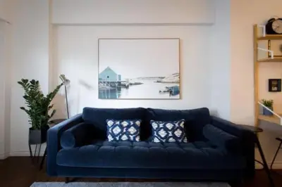 a blue couch in a living room with a picture at The Sherbrooke Suite 102 in Montréal