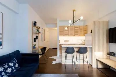 a living room with a couch and a kitchen at The Sherbrooke Suite 102 in Montréal