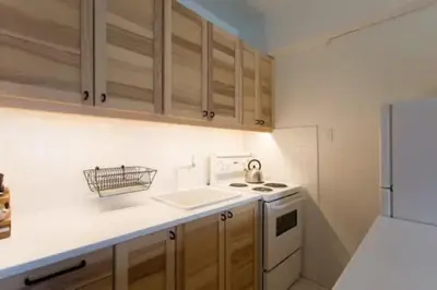 a kitchen with a sink and a stove and cabinets at The Sherbrooke Suite 102 in Montréal