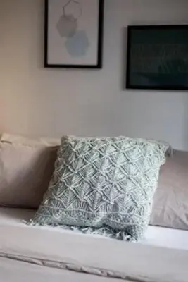 a pillow on a bed with two pictures on the wall at The Sherbrooke Suite 102 in Montréal