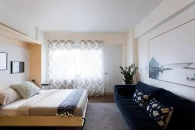 a bedroom with a bed and a couch and a window at The Sherbrooke Suite 102 in Montréal
