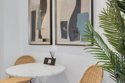 a white table and two chairs and a table and a plant at The Speakeasy Suite 502 With Parking in Montréal