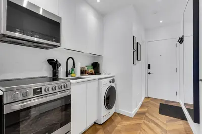 a white kitchen with a washer and dryer at The Speakeasy Suite 502 With Parking in Montréal