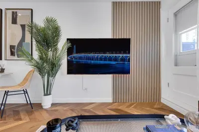 a living room with a television on a wall at The Speakeasy Suite 502 With Parking in Montréal