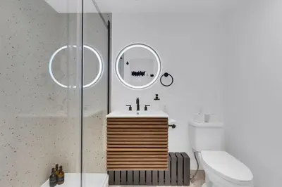 a bathroom with a sink and a toilet and a mirror at The Speakeasy Suite 502 With Parking in Montréal