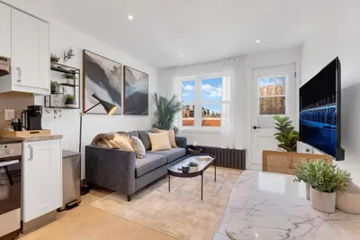 a living room with a couch and a tv at The Speakeasy Suite 501 With Parking in Montréal