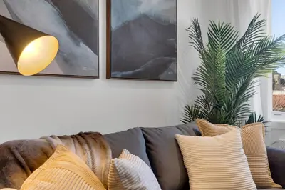 a living room with a couch with pillows and paintings at The Speakeasy Suite 501 With Parking in Montréal