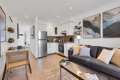 a living room with a couch and a kitchen at The Speakeasy Suite 501 With Parking in Montréal