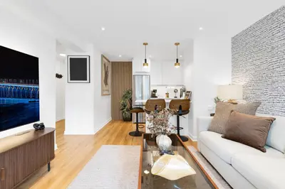 a living room with a white couch and a tv at Atelier Montreal Luxe 1BR King Bed With Parking in Montréal