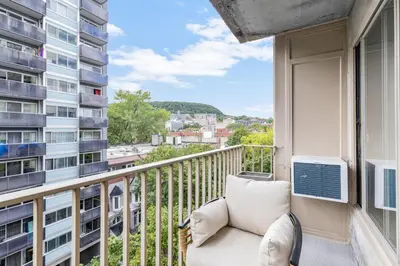 a balcony with a couch and a view of a city at Atelier Montreal Luxe 1BR King Bed With Parking in Montréal