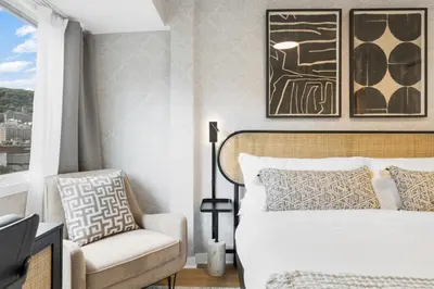 a bedroom with a bed and a chair and a window at Atelier Montreal Luxe 1BR King Bed With Parking in Montréal