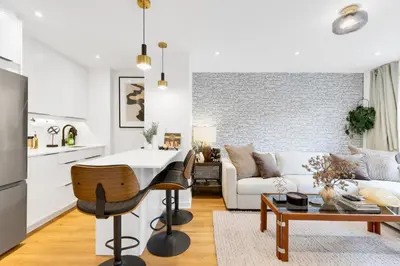 a kitchen and living room with a table and a couch at Atelier Montreal Luxe 1BR King Bed With Parking in Montréal