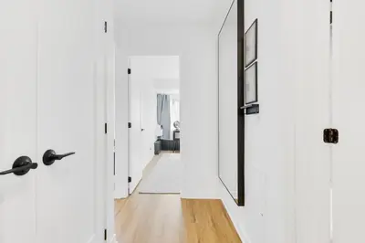 a hallway with white walls and white doors and a wooden floor at Atelier Montreal Luxe 1BR King Bed With Parking in Montréal