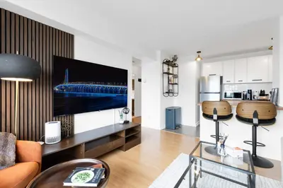 a living room with a flat screen tv on a wall at Downtown Montreal Horizon Suite With Parking in Montréal