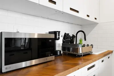 a kitchen counter with a microwave and a sink at Downtown Montreal Horizon Suite With Parking in Montréal