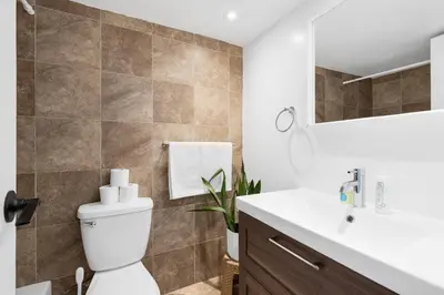 a bathroom with a toilet and a sink at Downtown Montreal Horizon Suite With Parking in Montréal