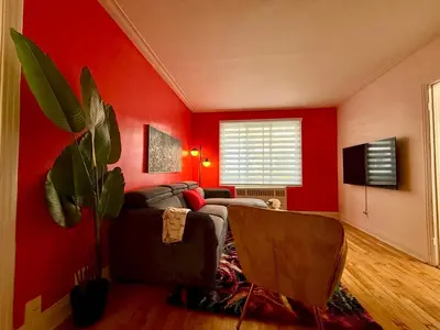 a red living room with a couch and a plant at Delightful Style & Comfort in Montreal! Sleep 4! in Montréal