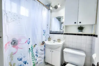 a white bathroom with a toilet and a sink at Delightful Style & Comfort in Montreal! Sleep 4! in Montréal