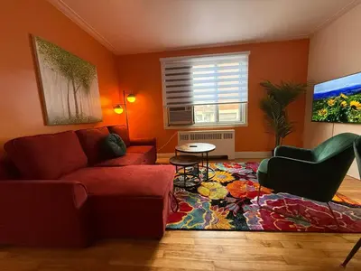 a living room with a red couch and a rug at Delightful Style & Comfort in Montreal! Sleep 4! in Montréal