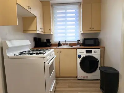 a kitchen with a stove and a washing machine at Delightful Style & Comfort in Montreal! Sleep 4! in Montréal