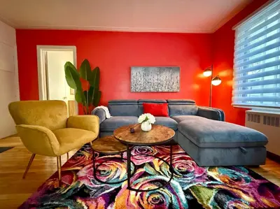 a living room with a blue couch and red walls at Delightful Style & Comfort in Montreal! Sleep 4! in Montréal