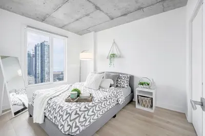 a white bedroom with a bed and a large window at Cozy Oasis Home Downtown Montreal - Free Indoor Parking-In Suite Laundry in Montréal