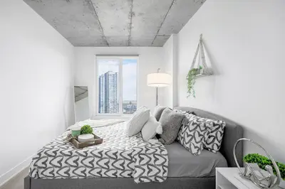 a bedroom with a bed and a large window at Cozy Oasis Home Downtown Montreal - Free Indoor Parking-In Suite Laundry in Montréal