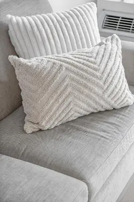 a white couch with a pillow on top of it at Cozy Oasis Home Downtown Montreal - Free Indoor Parking-In Suite Laundry in Montréal
