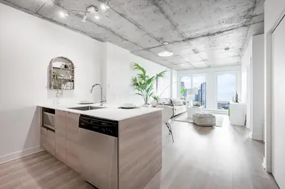 a kitchen with white walls and a concrete ceilings at Cozy Oasis Home Downtown Montreal - Free Indoor Parking-In Suite Laundry in Montréal