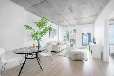 a white living room with a table and chairs at Cozy Oasis Home Downtown Montreal - Free Indoor Parking-In Suite Laundry in Montréal
