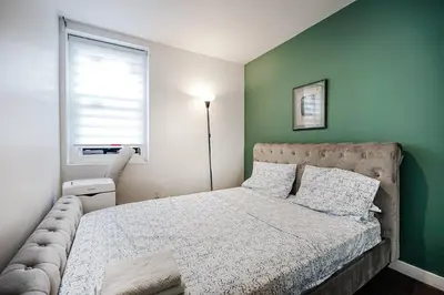 a bedroom with a bed and a green wall at Appartement design au cœur de Griffintown in Montréal