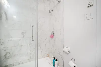 a bathroom with a shower with a glass door at Appartement design au cœur de Griffintown in Montréal