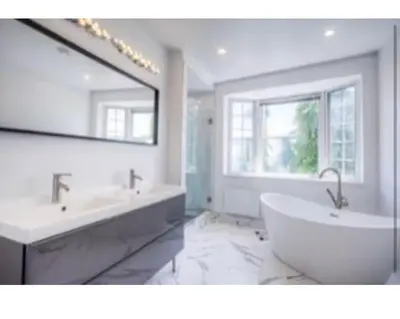 a bathroom with two sinks and a tub and a mirror at Victorian House B&B CozyWestmount in Westmount