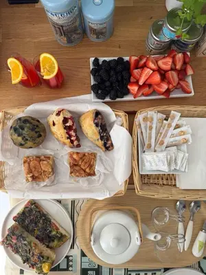 a table topped with plates of food and fruit at Victorian House B&B CozyWestmount in Westmount
