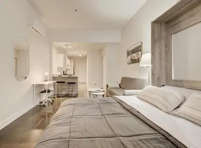 a bedroom with a large bed and a living room at Confort et style en plein Montréal in Montréal