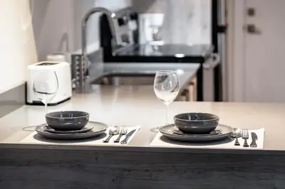 a table with two plates and two wine glasses at Confort et style en plein Montréal in Montréal