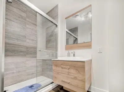 a bathroom with a shower and a sink and a mirror at Confort et style en plein Montréal in Montréal