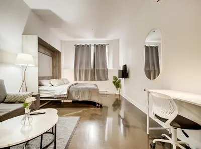 a white room with a bed and a couch at Confort et style en plein Montréal in Montréal