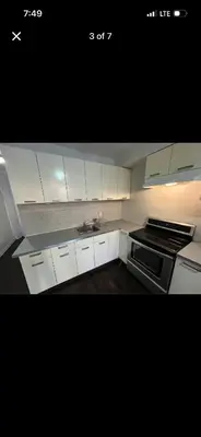a kitchen with white cabinets and a stove top oven at Mont roamyal in Montréal