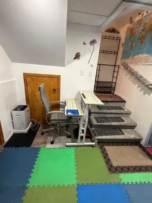 a room with a desk and a chair and stairs at Appartement Cool à Longueuil Plan A in Longueuil