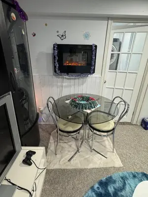 a glass table and chairs in a room with a fireplace at Appartement Cool à Longueuil Plan A in Longueuil