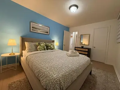 a bedroom with a bed with a blue wall at Lovely Vacation Home 2BR in MTL! in Montréal