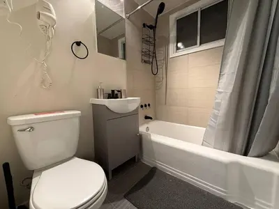 a bathroom with a toilet and a tub and a sink at Lovely Vacation Home 2BR in MTL! in Montréal