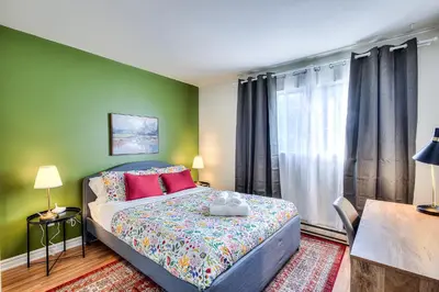 a bedroom with a bed and a green wall at Free Parking! Montreal Adventure Home - Modern & Spacious Comforts! in Montréal
