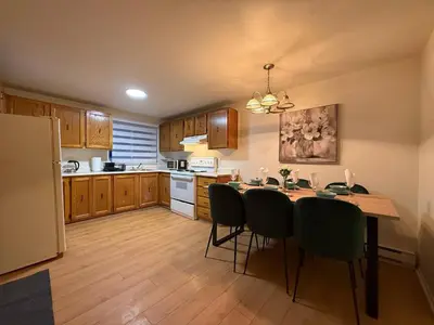 a kitchen with a table and chairs and a refrigerator at Free Parking! Montreal Adventure Home - Modern & Spacious Comforts! in Montréal