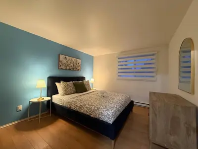 a bedroom with a bed and a blue wall at Free Parking! Montreal Adventure Home - Modern & Spacious Comforts! in Montréal